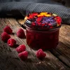 A jar of jam with raspberries on a wooden surface. Podgląd zdjęcia produktu