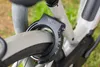 A close-up shot of a bicycle lock attached to the frame and wheel of a bicycle. Produktbild-Vorschau