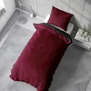 A top-down view of a bed with burgundy and anthracite bedding. Produktbild-Vorschau