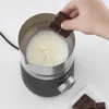 A hand is adding a piece of chocolate to a milk frother with milk inside. Produktbild-Vorschau