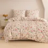 A neatly made bed with a floral and rabbit-patterned duvet cover and pillows, set against a plain wall. Produktbild-Vorschau