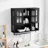 A black wall-mounted cabinet with glass doors, filled with toiletries and towels, is shown above a sink in a bathroom setting. Produktbild-Vorschau
