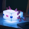 A Minecraft Axolotl lamp sits on a table next to a notebook and pencil. Anteprima dell’immagine prodotto