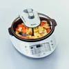 A white multi-cooker with a lid and a mixing attachment, filled with chopped vegetables. Anteprima dell’immagine prodotto