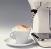 A close-up of a vintage-style espresso machine with a steaming wand over a cup of cappuccino. Podgląd zdjęcia produktu