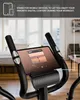 A tablet is mounted on an exercise bike, displaying a music app. The background shows a living room with windows. Produktbild-Vorschau