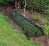 A garden tunnel made of black mesh is placed over grass in a garden setting. Produktbild-Vorschau