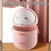 A cute pink duck-shaped trash can with its lid open, placed on a wooden surface. Produktbild-Vorschau