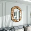 A decorative mirror hangs on a wall above a sofa. Produktbild-Vorschau
