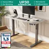 A modern standing desk is set up in a home office environment with a monitor, keyboard, headphones, and a coffee cup. Produktbild-Vorschau
