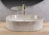 A close-up view of a modern bathroom sink with a gold faucet. Podgląd zdjęcia produktu