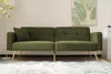 A green sofa with gold legs is shown in a well-lit room with a white rug and a painting on the wall. Produktbild-Vorschau