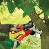 A person is using a Black & Decker electric chainsaw to trim a tree branch. Produktbild-Vorschau