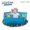 A baby sitting in a blue ball pit filled with colorful balls. Anteprima dell’immagine prodotto