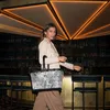 A woman walks through a bar with a shopping bag. Anteprima dell’immagine prodotto