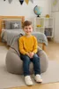 A young boy sits on a beanbag chair in a child's bedroom. Produktbild-Vorschau