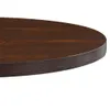 Close-up of the edge of a round, dark brown wooden table. Náhled obrázku produktu