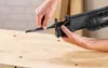 A person is shown inserting a saw blade into a reciprocating saw. Produktbild-Vorschau