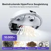 A robot vacuum cleaner is shown from underneath, demonstrating its suction power on debris. Produktbild-Vorschau