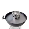 A close-up shot of a grilling accessory placed inside a kettle grill. Voir les images du produit