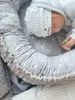 A newborn baby sleeping in a gray babynest with a dandelion print. Produktbild-Vorschau