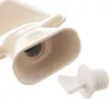 Close-up of the opening of a beige hot water bottle with its stopper next to it. Podgląd zdjęcia produktu