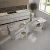 A modern dining room with a large grey table and white chairs, set against a clean white and grey background. Produktbild-Vorschau