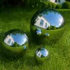 Three polished stainless steel garden spheres of different sizes are placed on a green lawn in front of a white house. Produktbild-Vorschau