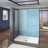 A modern bathroom with a glass shower enclosure against a blue brick wall, overlooking a scenic view. Produktbild-Vorschau