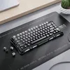 A gaming keyboard is placed on a desk mat next to a laptop and a potted plant. Produktbild-Vorschau