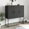 A black metal cabinet with three doors on a metal stand, placed in a room with a plant and vases. Produktbild-Vorschau