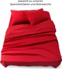 A red bed sheet and pillowcases are neatly arranged on a bed. Produktbild-Vorschau