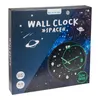 The image shows the packaging of a wall clock with a space theme. The clock itself is visible through a circular window on the box. Náhled obrázku produktu