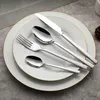 A set of silverware is neatly arranged on two white plates with gold trim. Produktbild-Vorschau