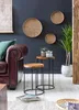 A living room scene with a leather sofa, side tables, and decorative wall hangings. Náhled obrázku produktu