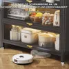 A kitchen cabinet with items inside, and a robot vacuum cleaner on the floor. Anteprima dell’immagine prodotto