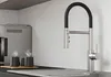 A modern kitchen sink area with a coffee machine and two steaming mugs, featuring a sleek faucet. Produktbild-Vorschau