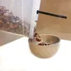 Cereal being poured from a clear plastic container into a tan bowl. Produktbild-Vorschau
