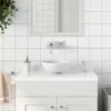A clean, modern bathroom sink area with white tiled walls and a white ceramic sink. Náhled obrázku produktu