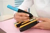 A person is using a blue and black glue gun to attach a wooden dowel to a black and yellow striped object. Produktbild-Vorschau