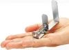 A person's open palm holding a small metal spring clamp. Produktbild-Vorschau