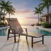 A lounge chair is placed by an infinity pool with palm trees and a sunset in the background. Produktbild-Vorschau