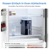 A water filter pitcher is placed inside a refrigerator, with dimensions indicated for fitting into the refrigerator compartment. Podgląd zdjęcia produktu