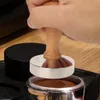 A hand is using a coffee tamper to press coffee grounds in an espresso machine portafilter. Náhled obrázku produktu