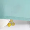 A close-up of a light green fabric with lemons and text on the side. Produktbild-Vorschau