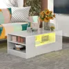 A modern living room scene featuring a white high-gloss coffee table with integrated lighting, a colorful sofa, and decorative items. Náhled obrázku produktu