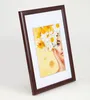 A framed picture of a woman with flowers in her hair. Produktbild-Vorschau