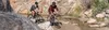 Two people riding bicycles on a rocky trail with a stream. Produktbild-Vorschau