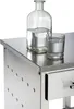 A close-up view of a stainless steel kitchen cart with a glass bottle and glass of water on top. Anteprima dell’immagine prodotto