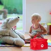 A young child plays doctor with a large stuffed polar bear, using a toy medical kit. Anteprima dell’immagine prodotto